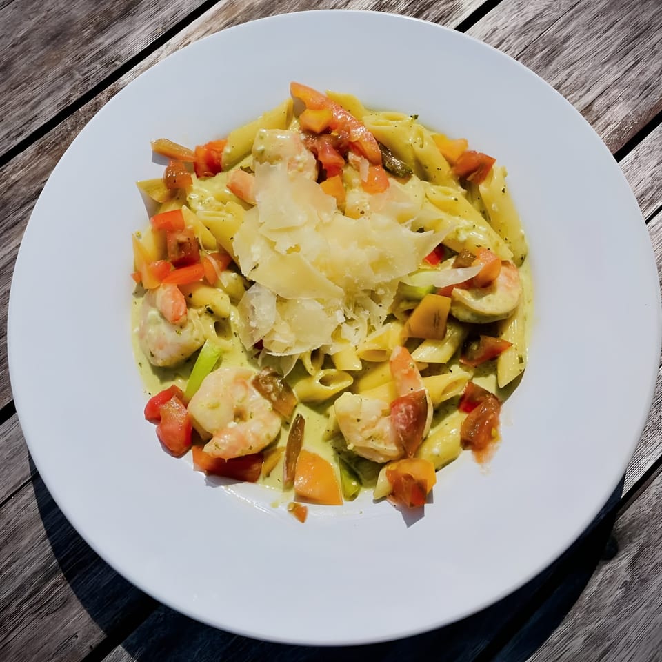 Penne pasta with shrimp, diced tomatoes, and shaved parmesan cheese in a creamy sauce.